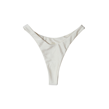 Cream Aláti Delfini high-cut thong bikini bottom, front flat-lay, with V-shaped waist and gold logo